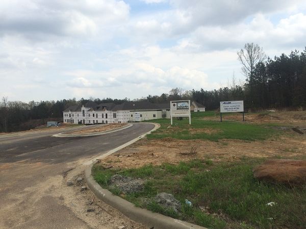 Large White Building In The Middle Of A Grassy Field - Oxford, MS - Precision Engineering Corporation