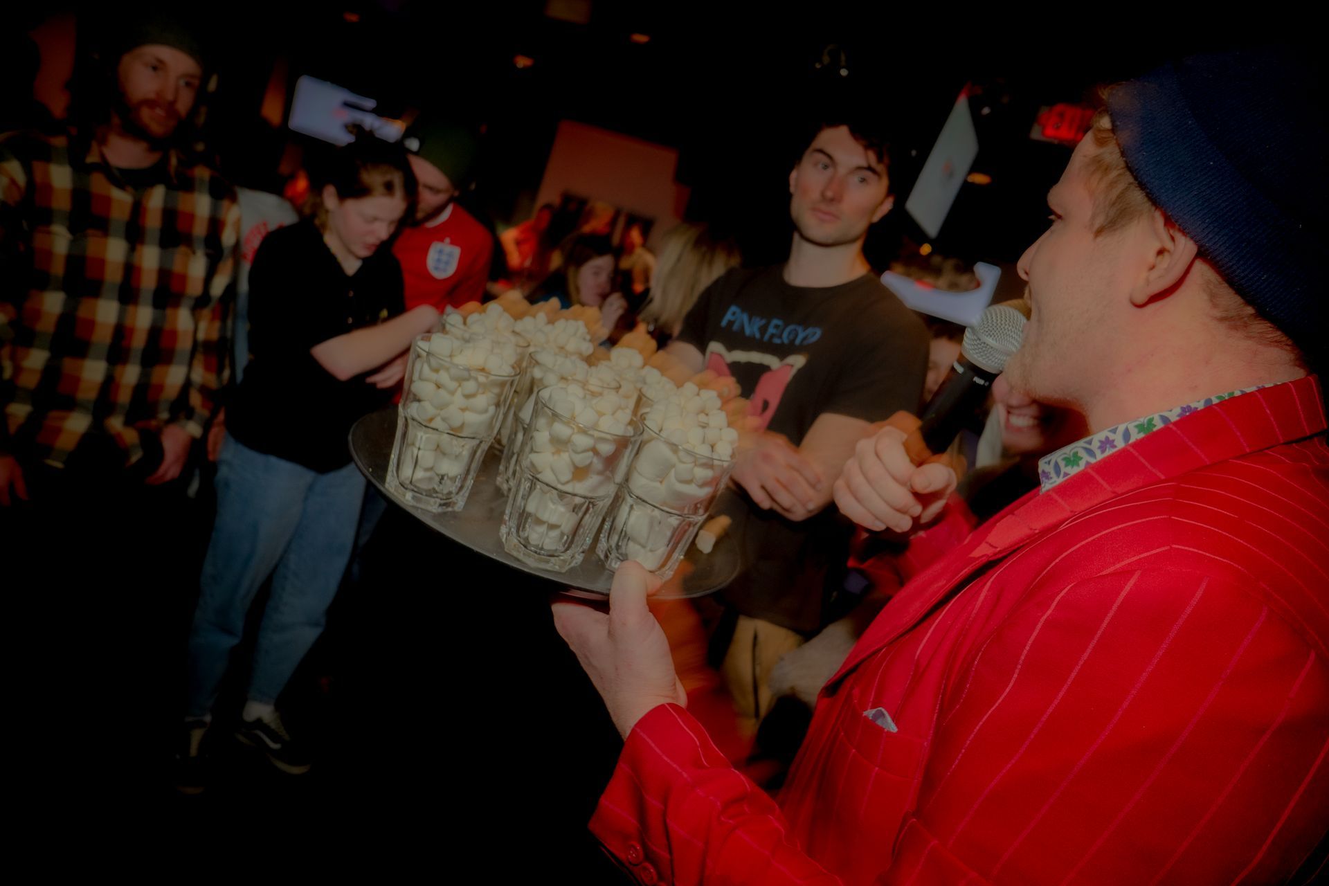 A man is holding a tray of popcorn in front of a crowd of people.