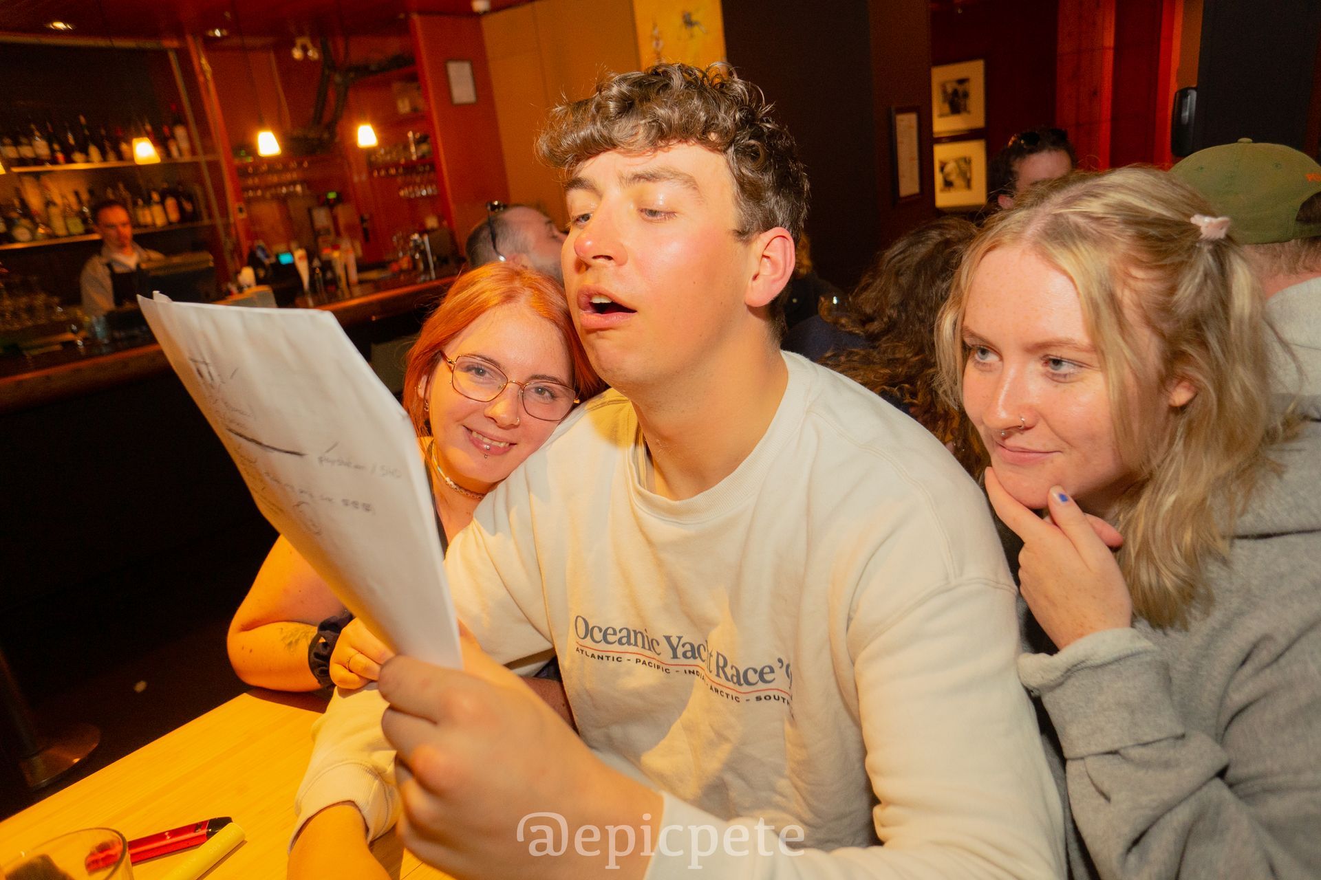 A group of people are sitting at a table looking at a piece of paper.