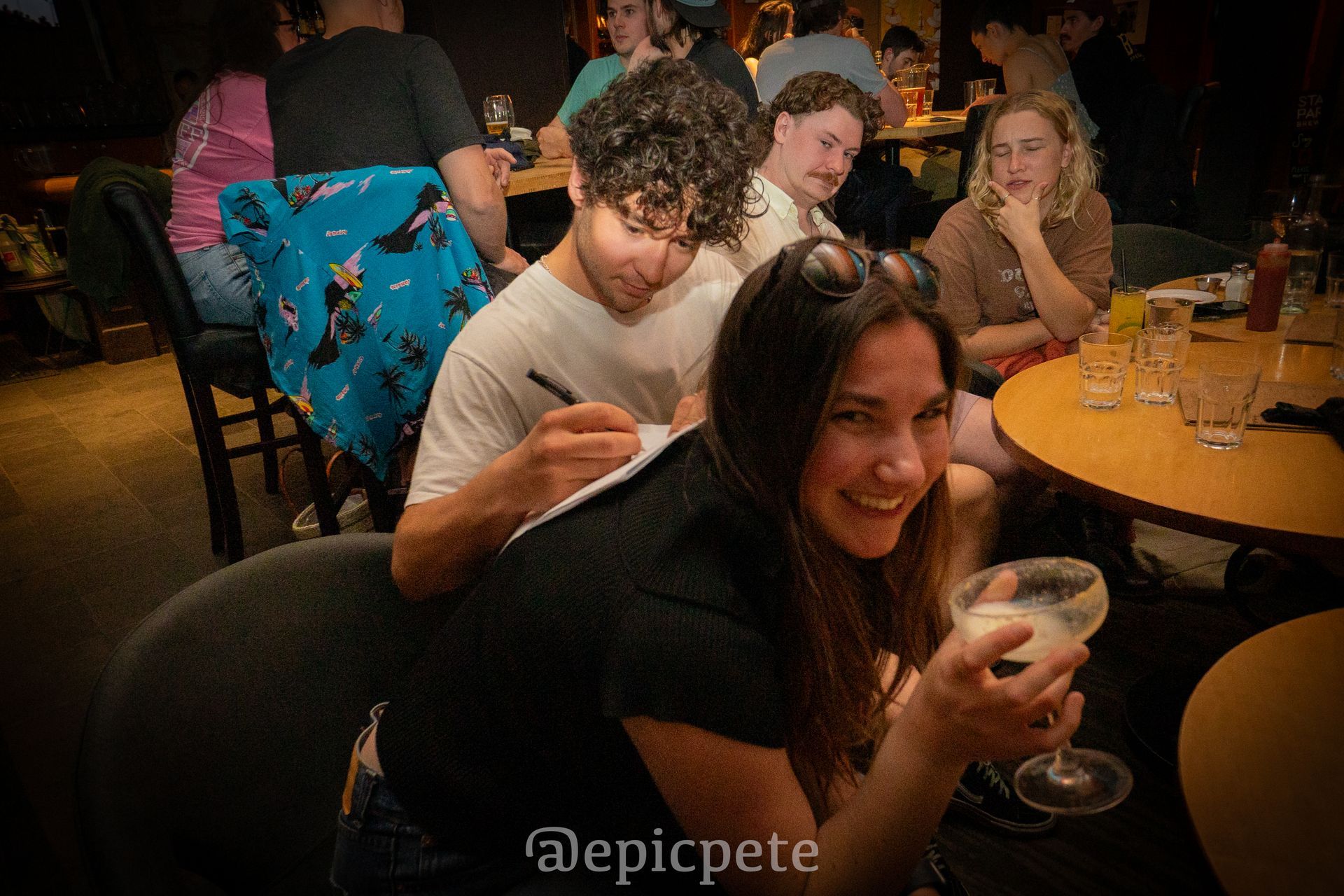 A group of people are sitting at tables in a restaurant.