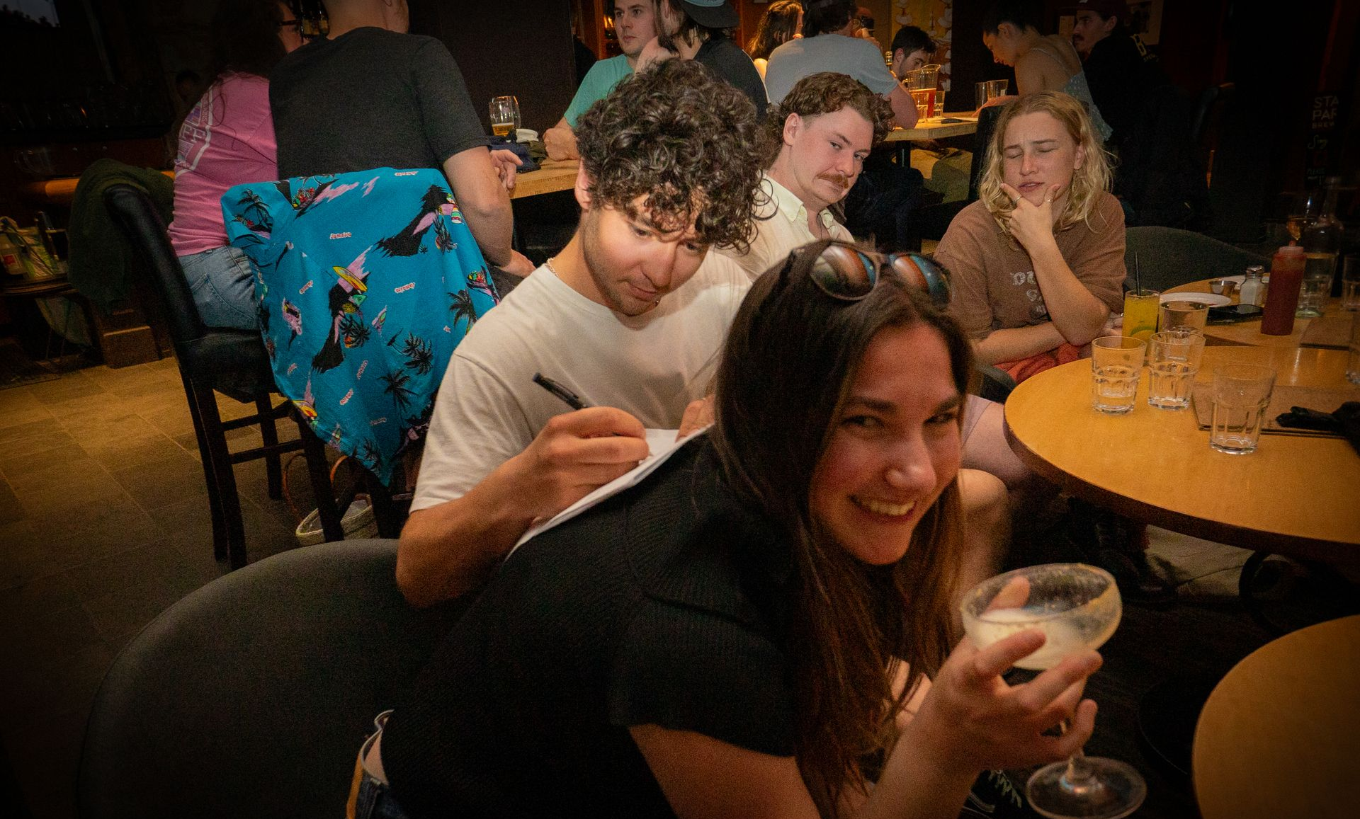 A group of people are sitting at tables in a restaurant.