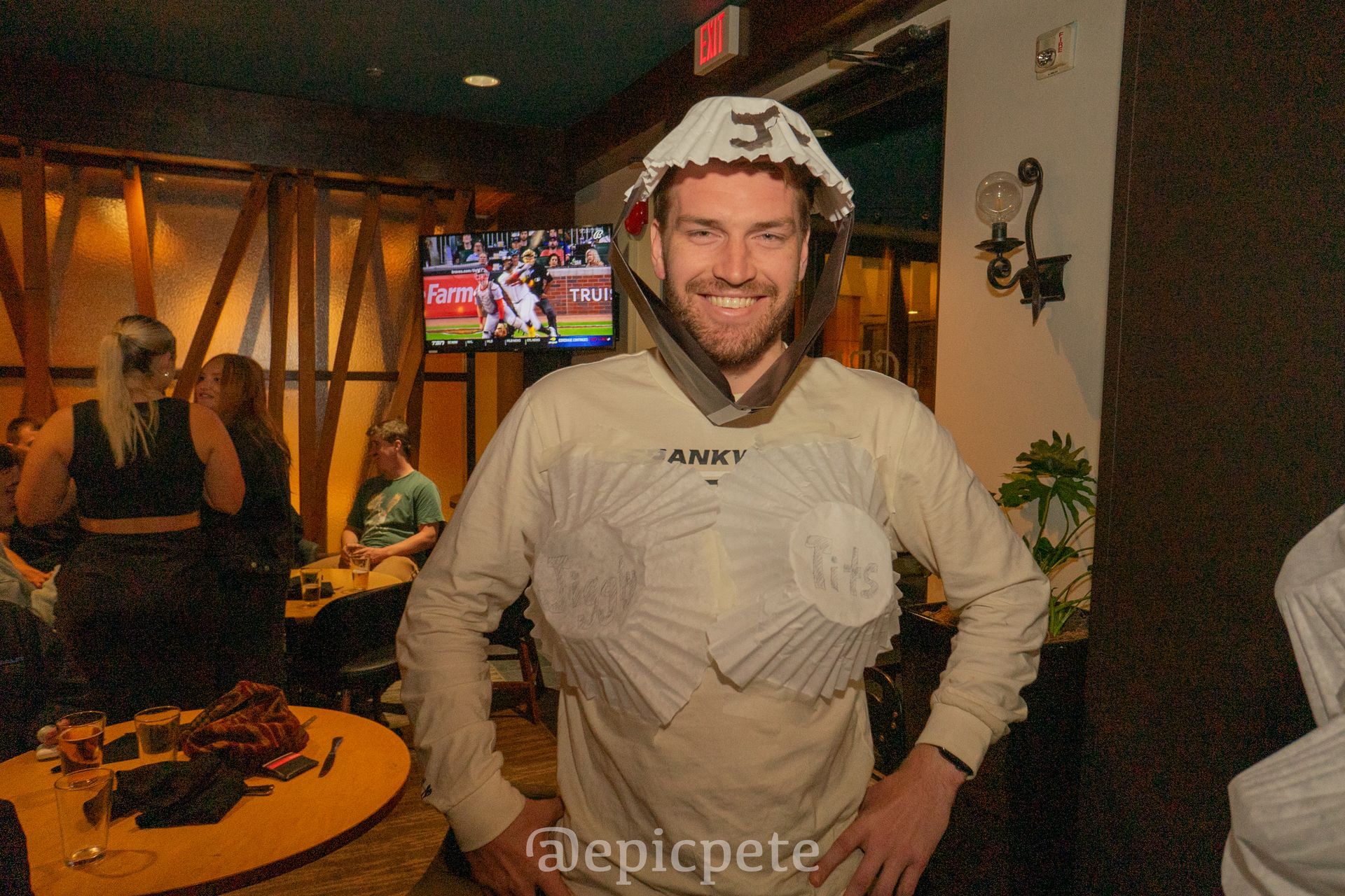 A man wearing a shark costume is standing in a restaurant.