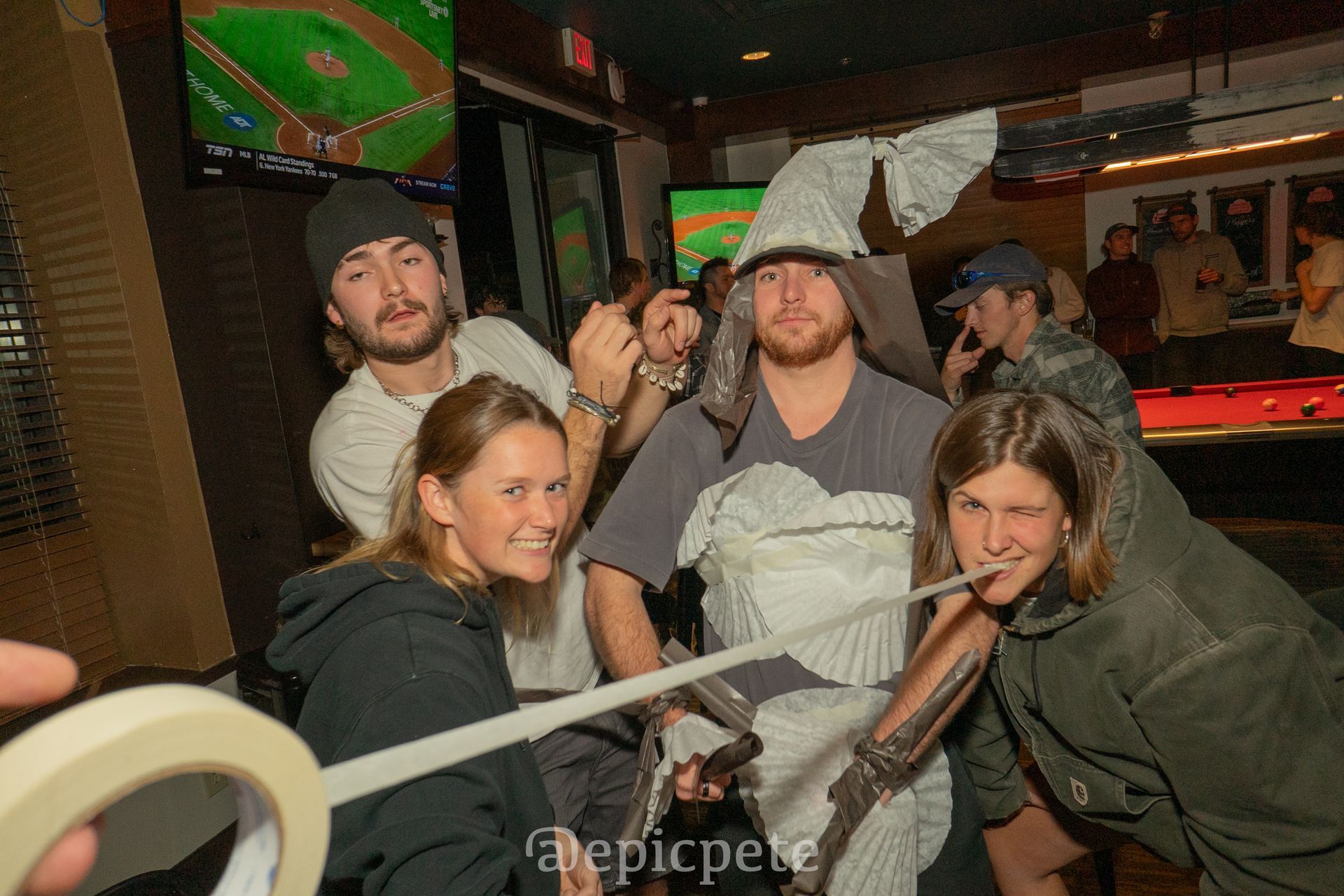 A group of people are posing for a picture in front of a pool table.