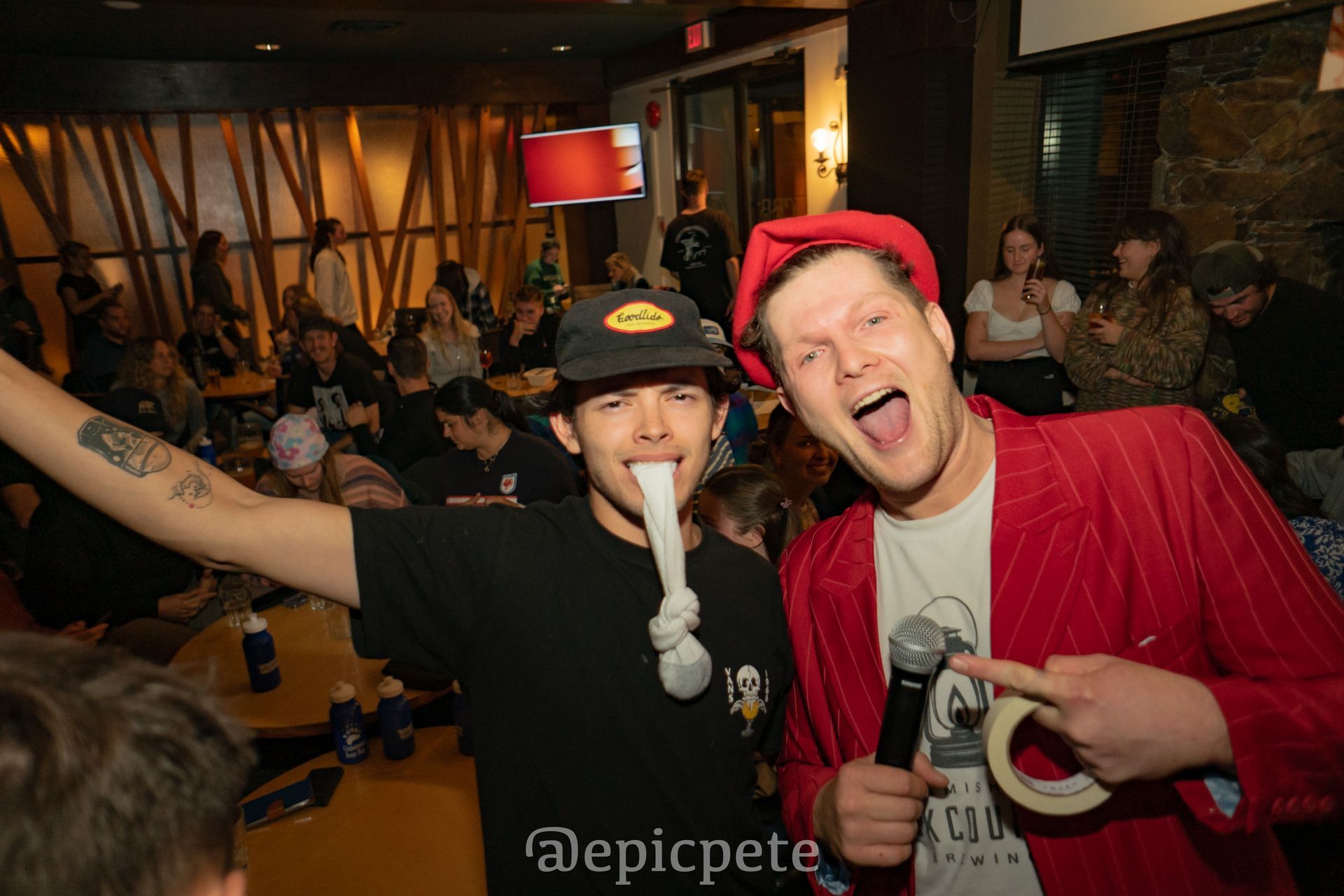 Two men are standing next to each other in a room holding microphones.
