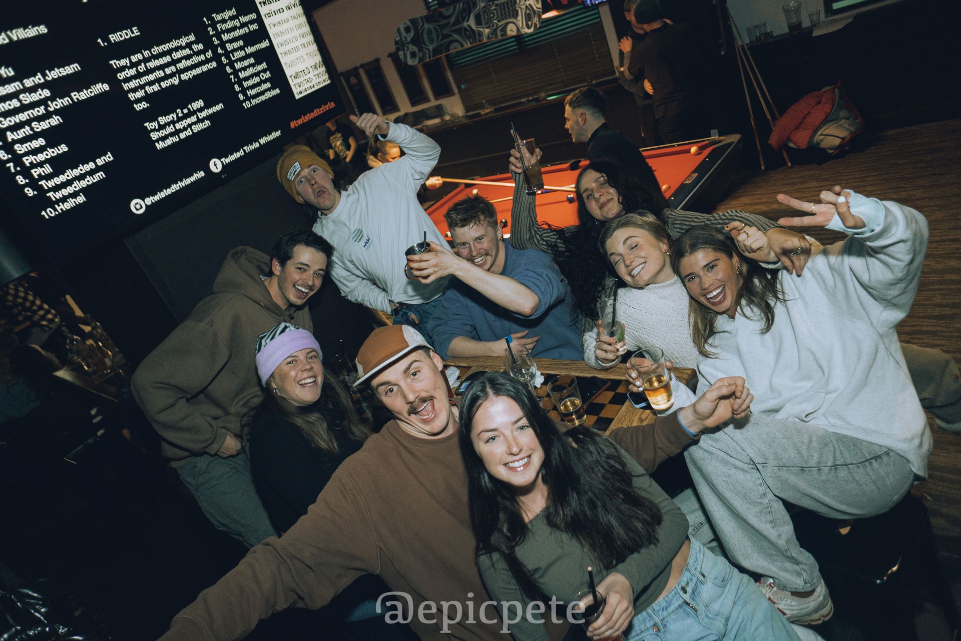 A group of people are posing for a picture in a bar.