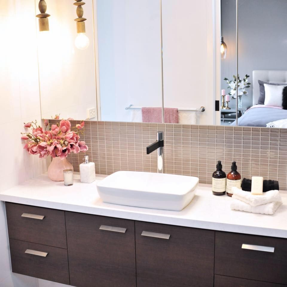 A bathroom with a sink and a large mirror