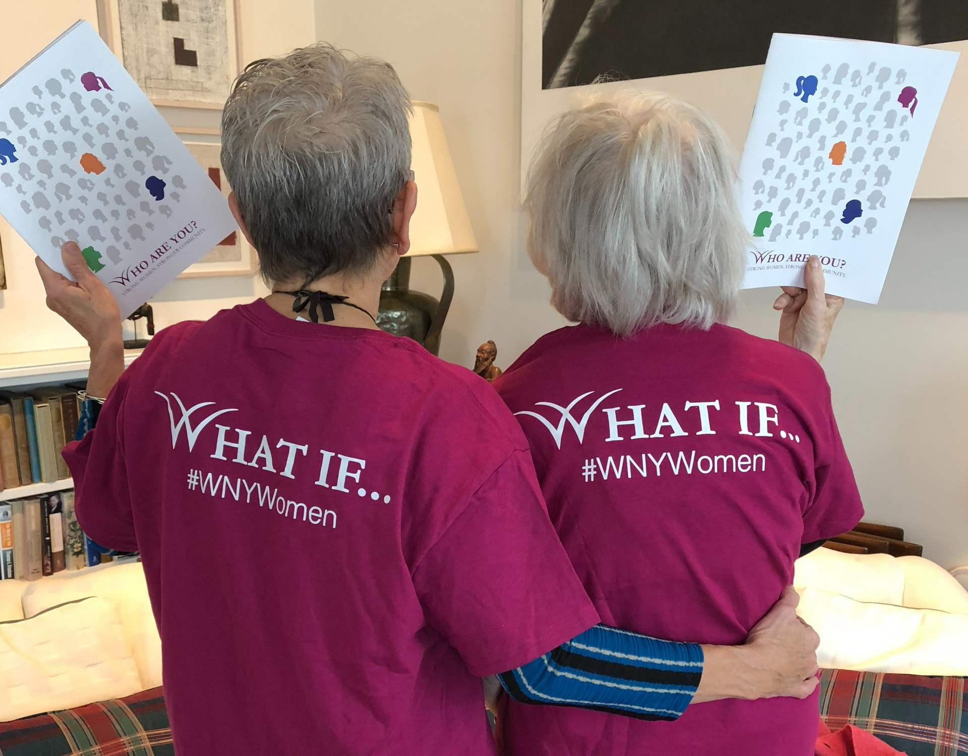 A group of women are standing next to each other in front of a brick wall.