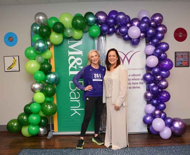 Two women are standing in front of a sign that says m & t bank