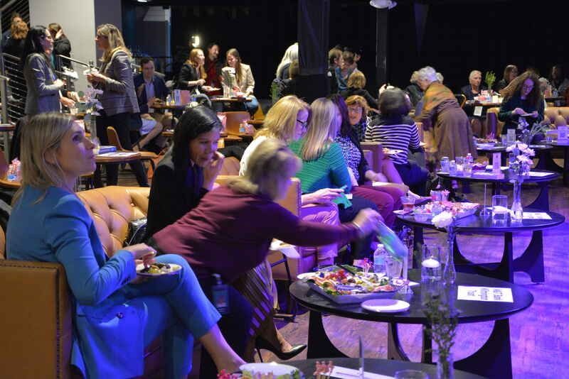 A group of people are sitting at tables in a room.