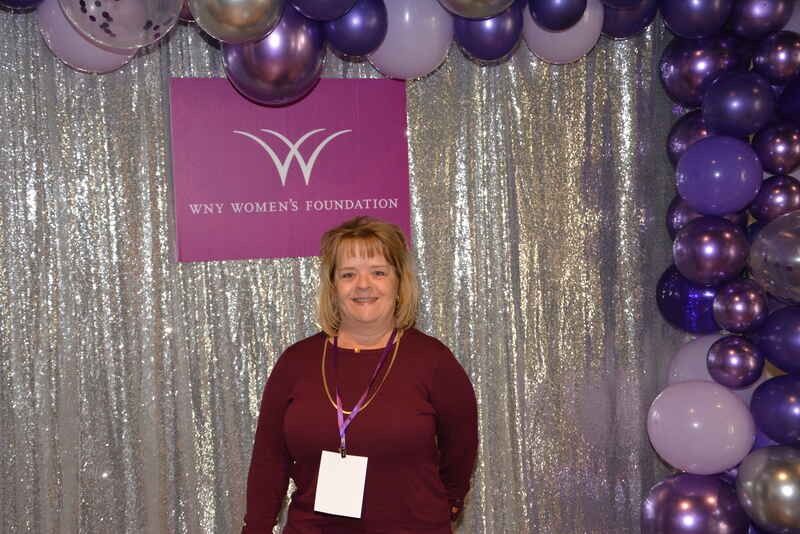 A woman is standing in front of a sign that says why women 's foundation