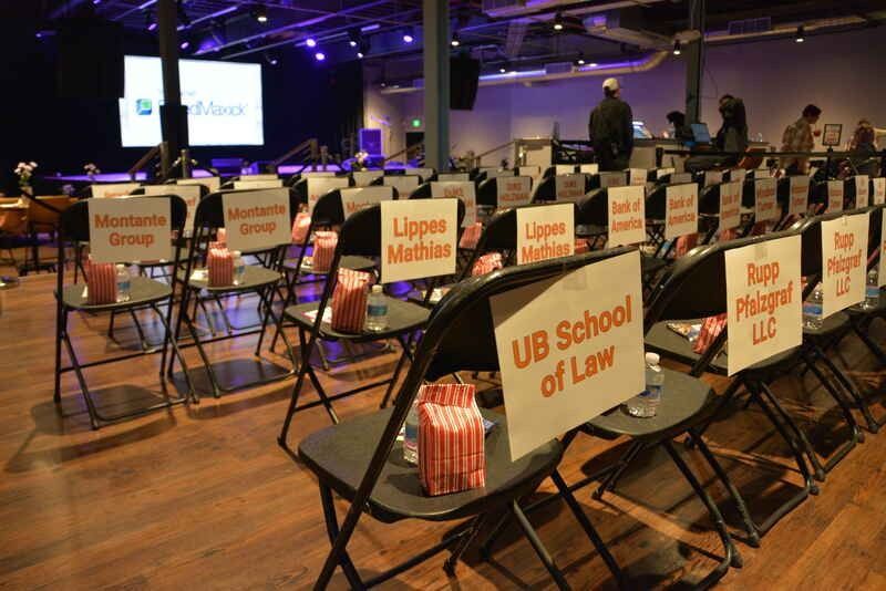 A row of folding chairs with signs on them that say ub school of law