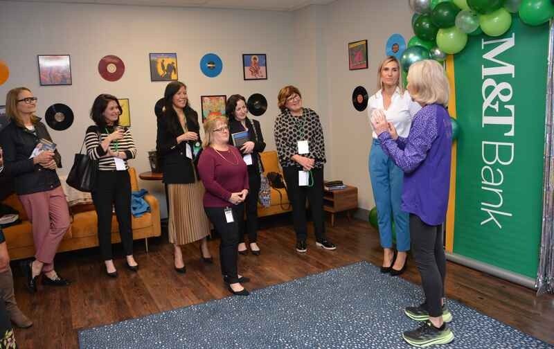 A group of women are standing in a room in front of a sign that says m & t bank.