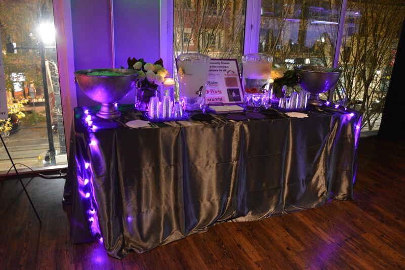 A table with purple lights on it is sitting in front of a window.