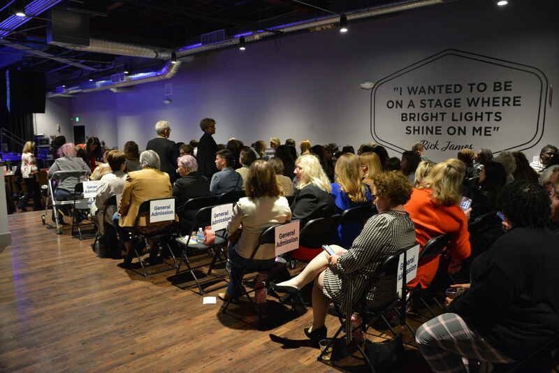 A large group of people are sitting in chairs in a room.