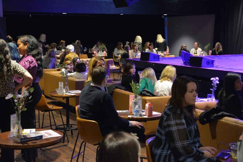 A group of people are sitting at tables in a room.