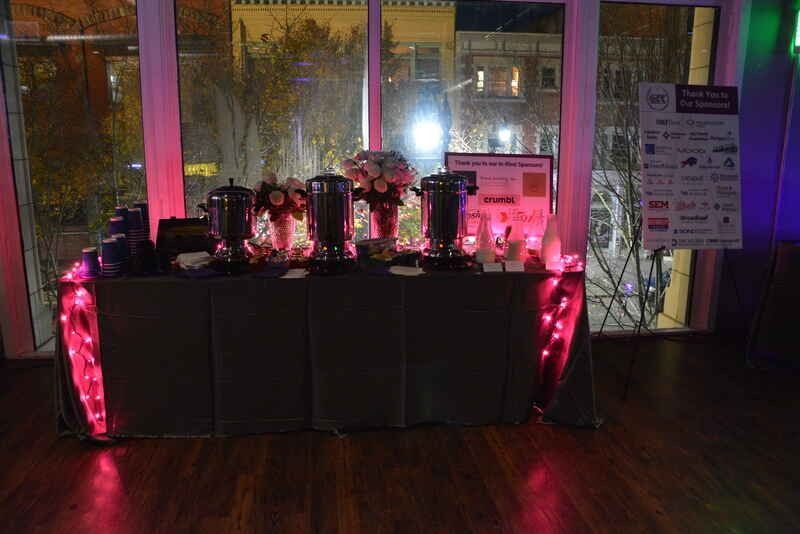 A table decorated with pink lights and flowers is sitting in front of a window.