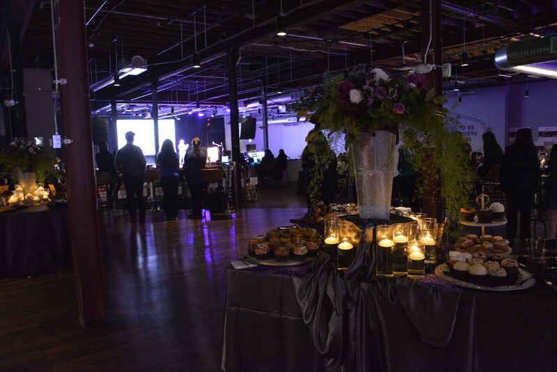 A table with cupcakes and candles on it in a dark room.