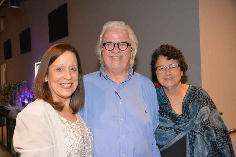 A man and two women are posing for a picture together.