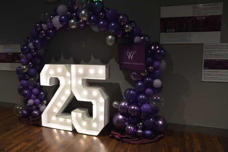 A large lighted number 25 is surrounded by purple balloons.