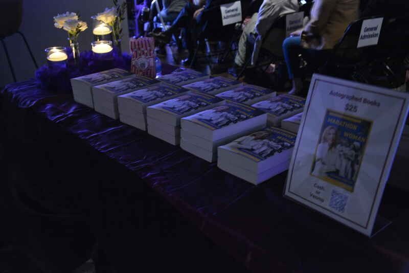 A table with a bunch of books and candles on it