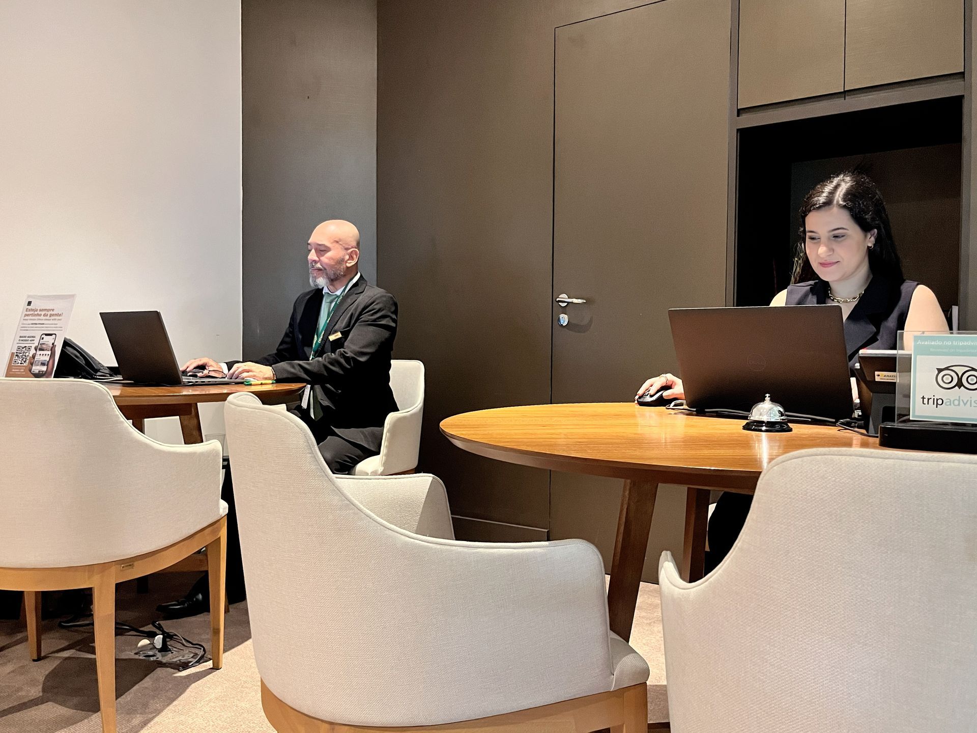 Um homem e uma mulher estão sentados à mesa com laptops.