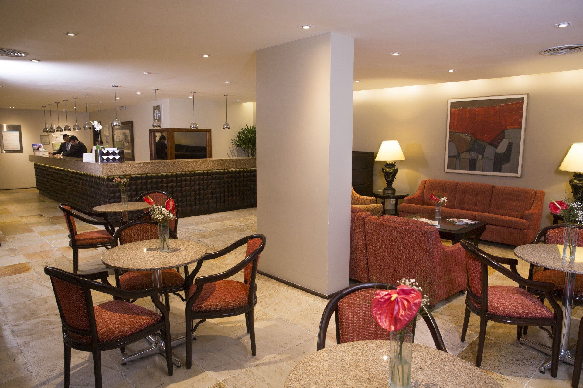 Um lobby de hotel com mesas e cadeiras e um sofá