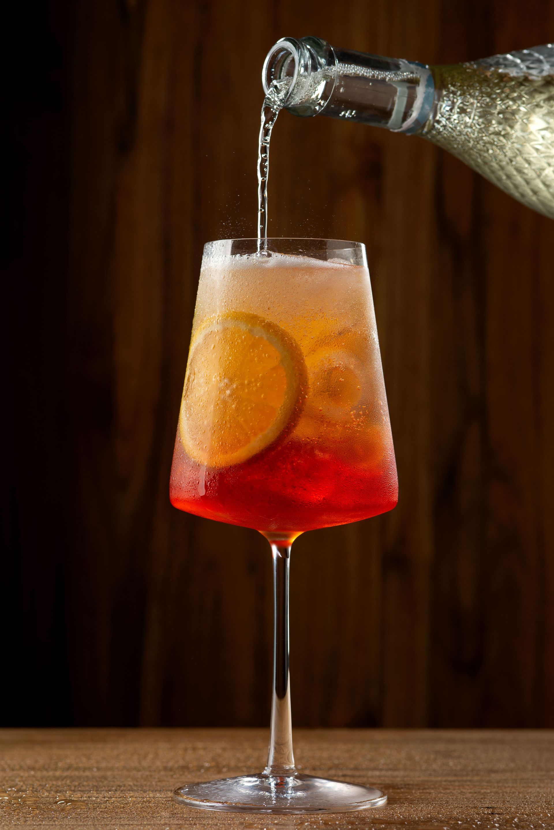 Uma taça de vinho está sendo despejada de uma garrafa em um copo.