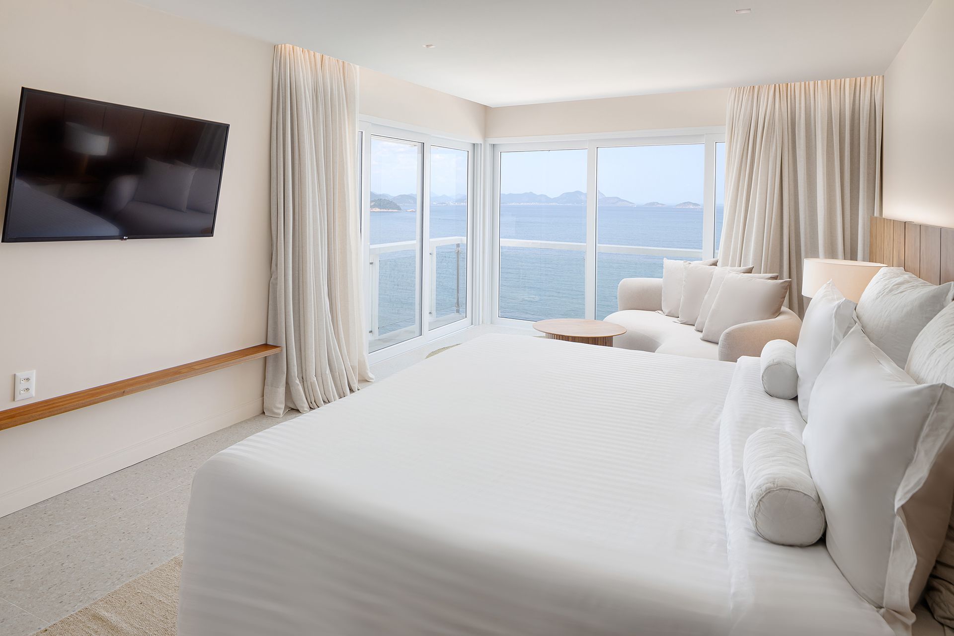 Um quarto de hotel com uma cama king size e vista para o oceano