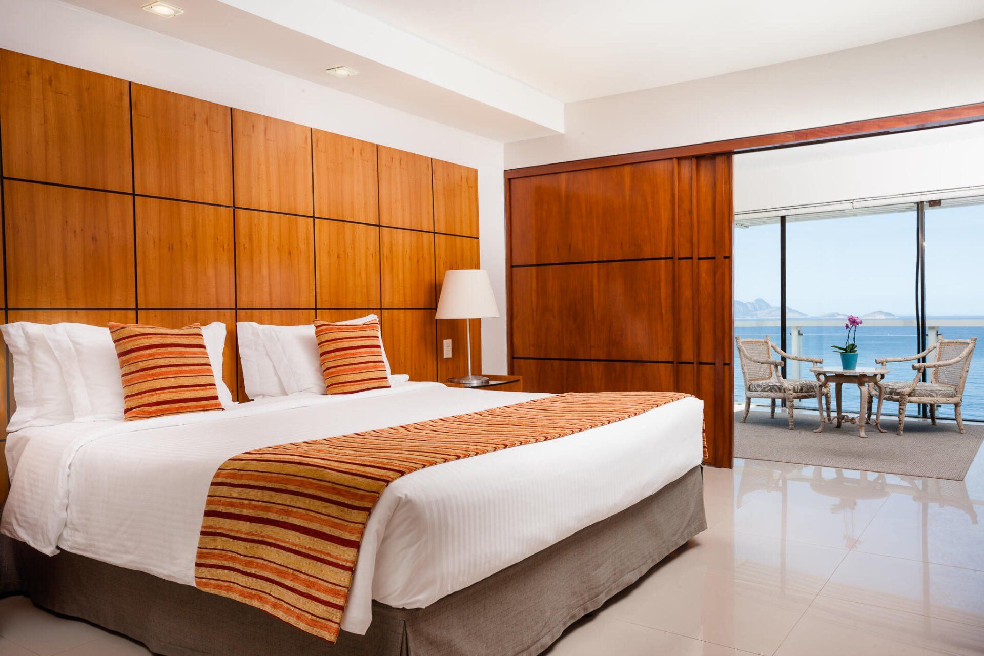 Um quarto de hotel com uma cama king size e vista para o oceano