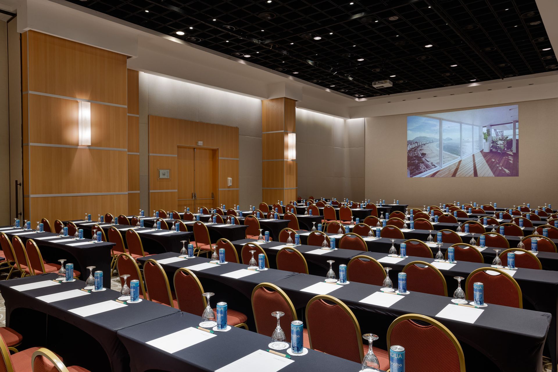 Uma grande sala de conferências com mesas e cadeiras preparadas para uma reunião