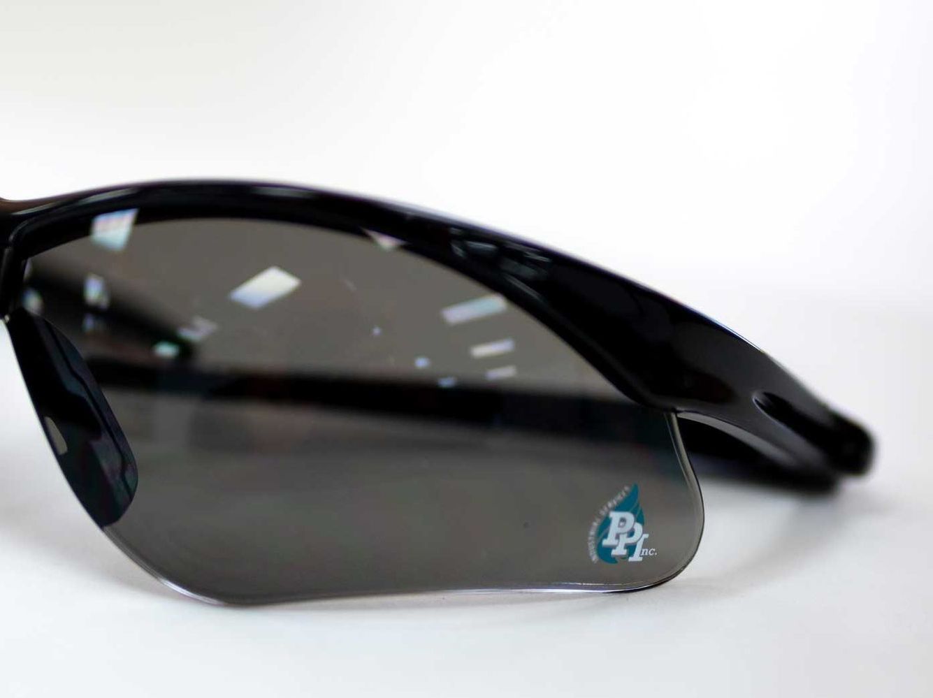 A pair of sunglasses with a water drop on the lens