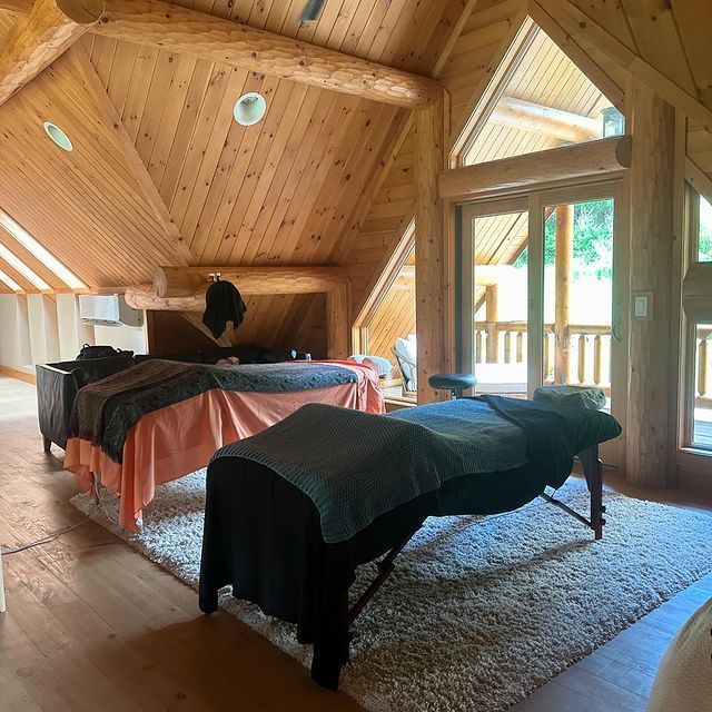 A room with two massage tables and a large window