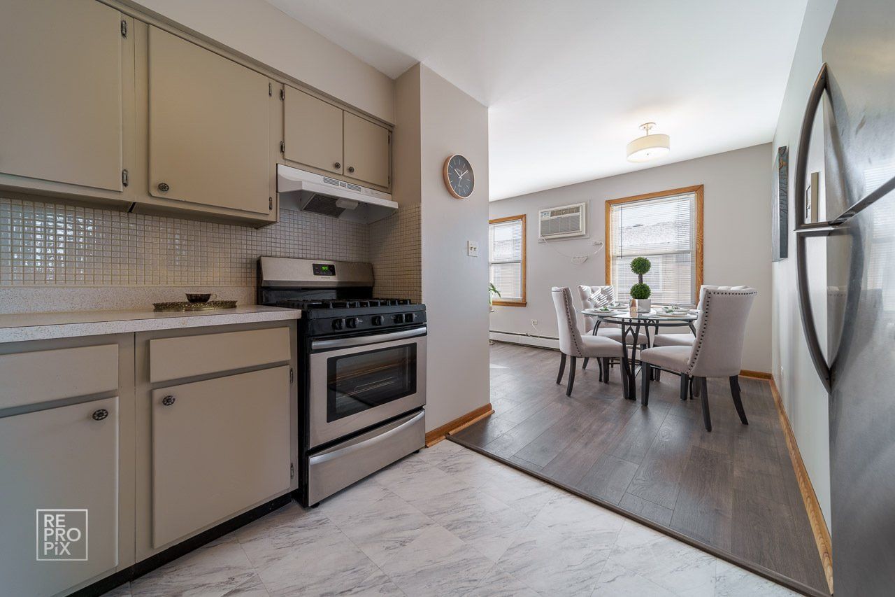 kitchen with stainless steel appliances and marble floor with view of dining area