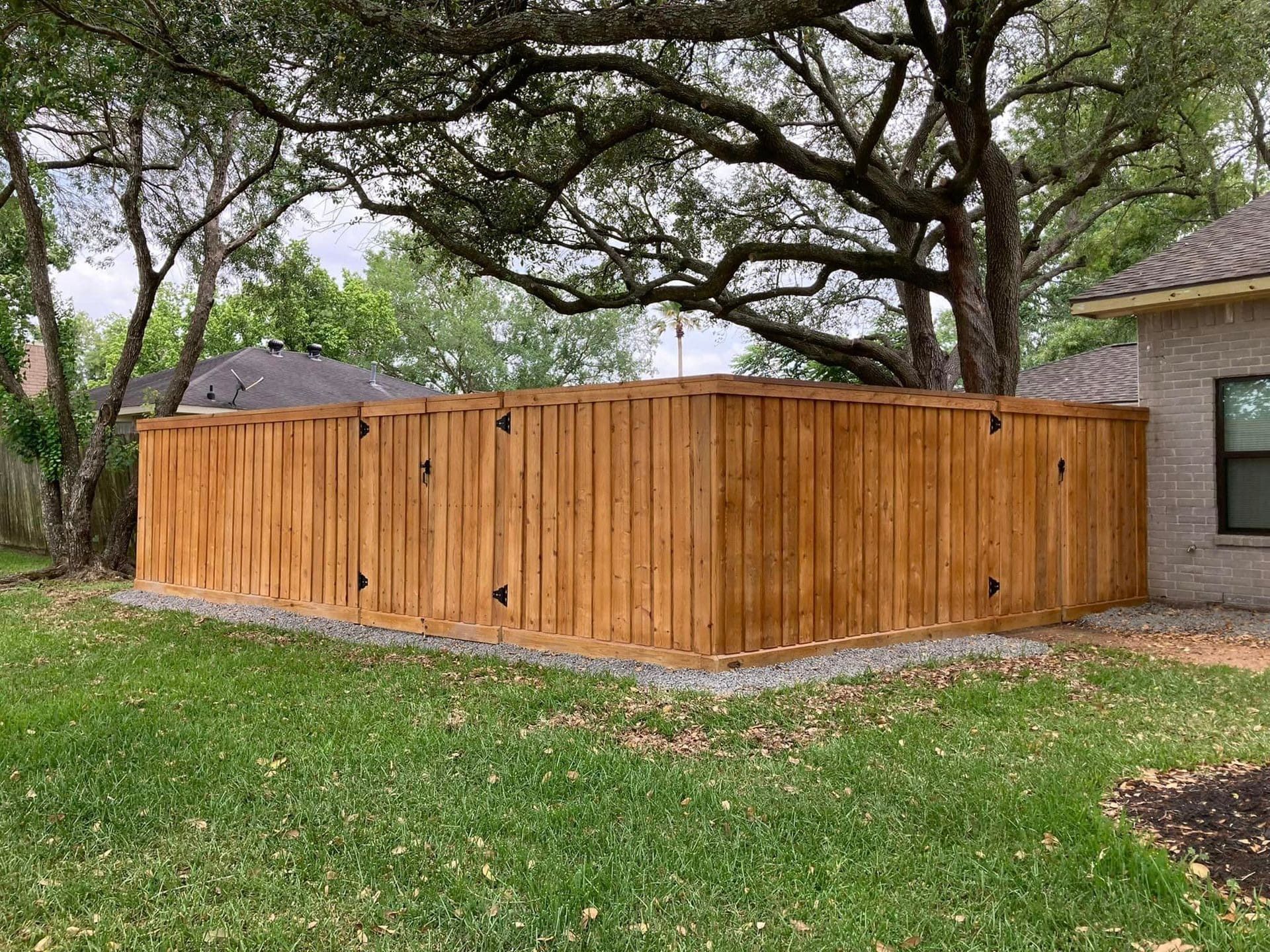 Wooden fence surrounding a grassy yard near a house, by Allen's Tree and Fence.