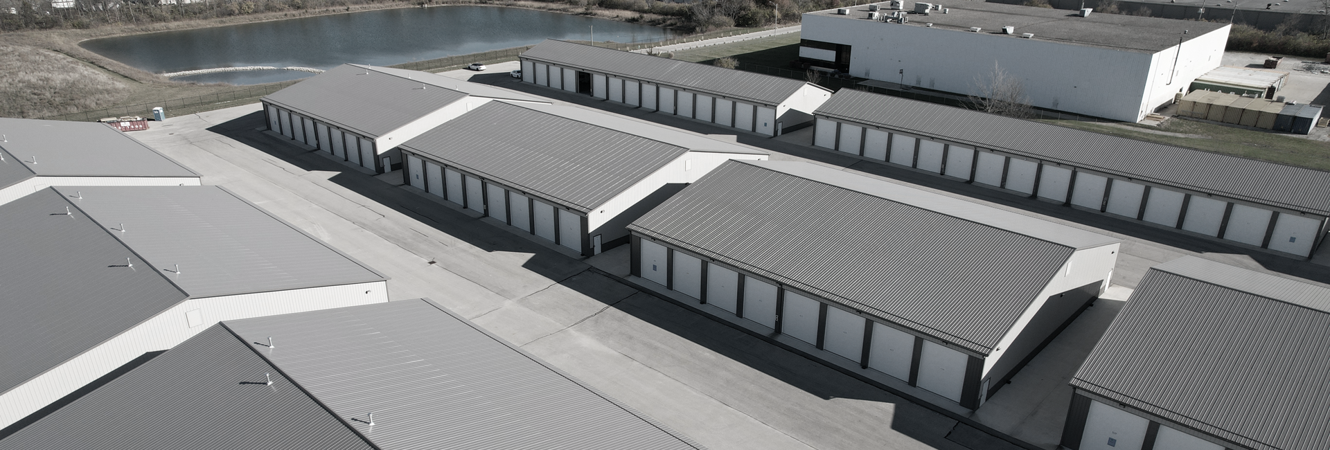 Aerial view of a self-storage facility with many units and a large white building.