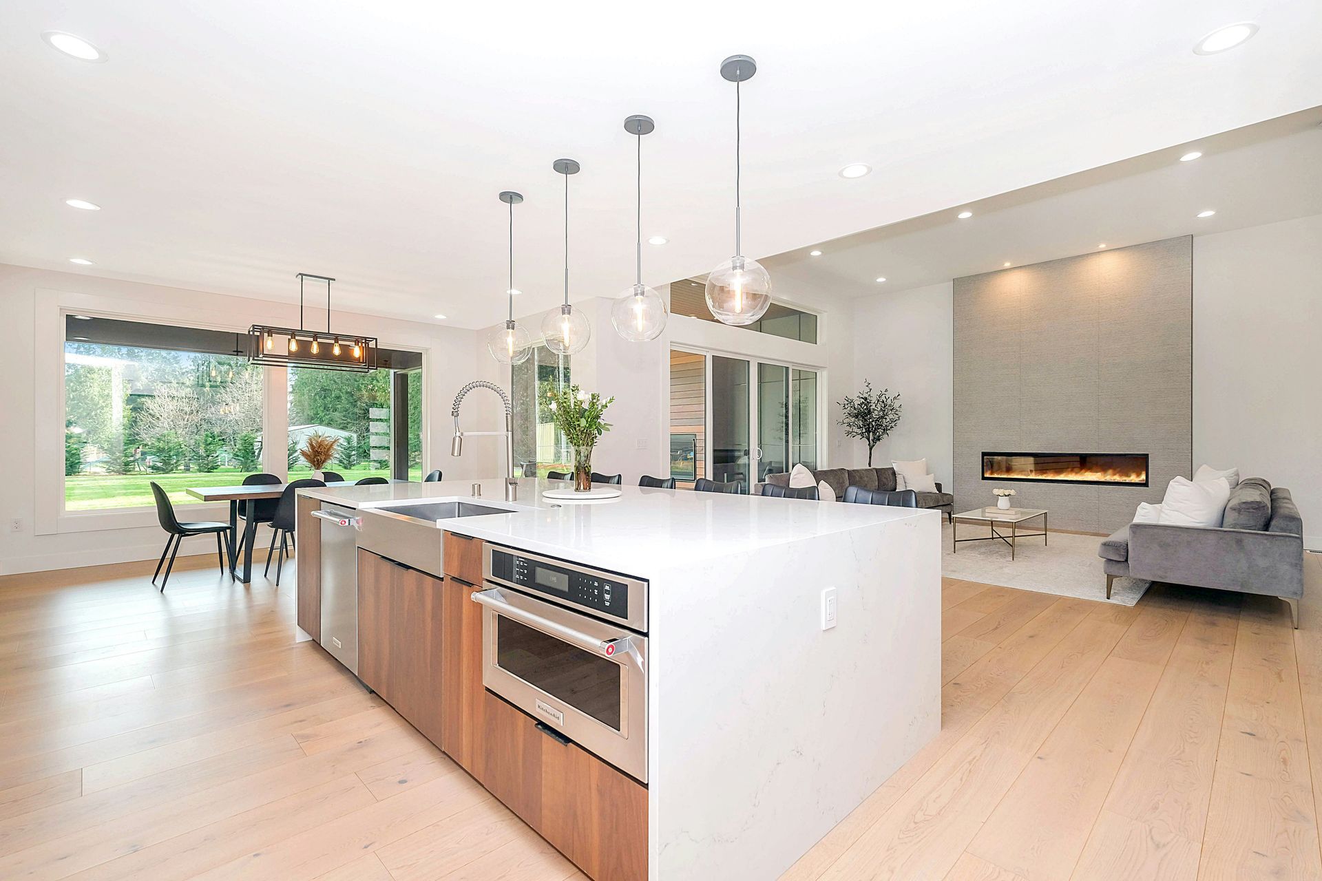 Modern kitchen island with white counters, built-in cooktop, and open living space bathroom remodeling in Avondale, AZ