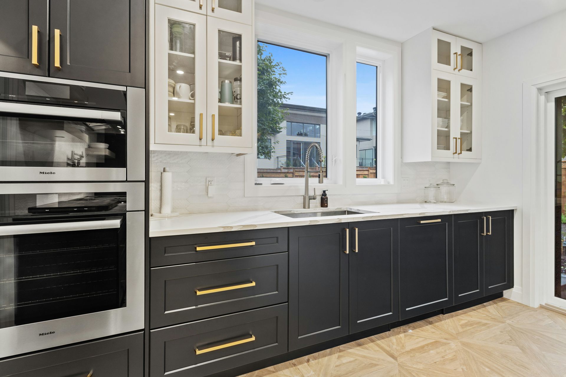 Kitchen with black lower cabinets, white uppers, and gold hardware after kitchen and bathroom remodeling in Avondale, AZ