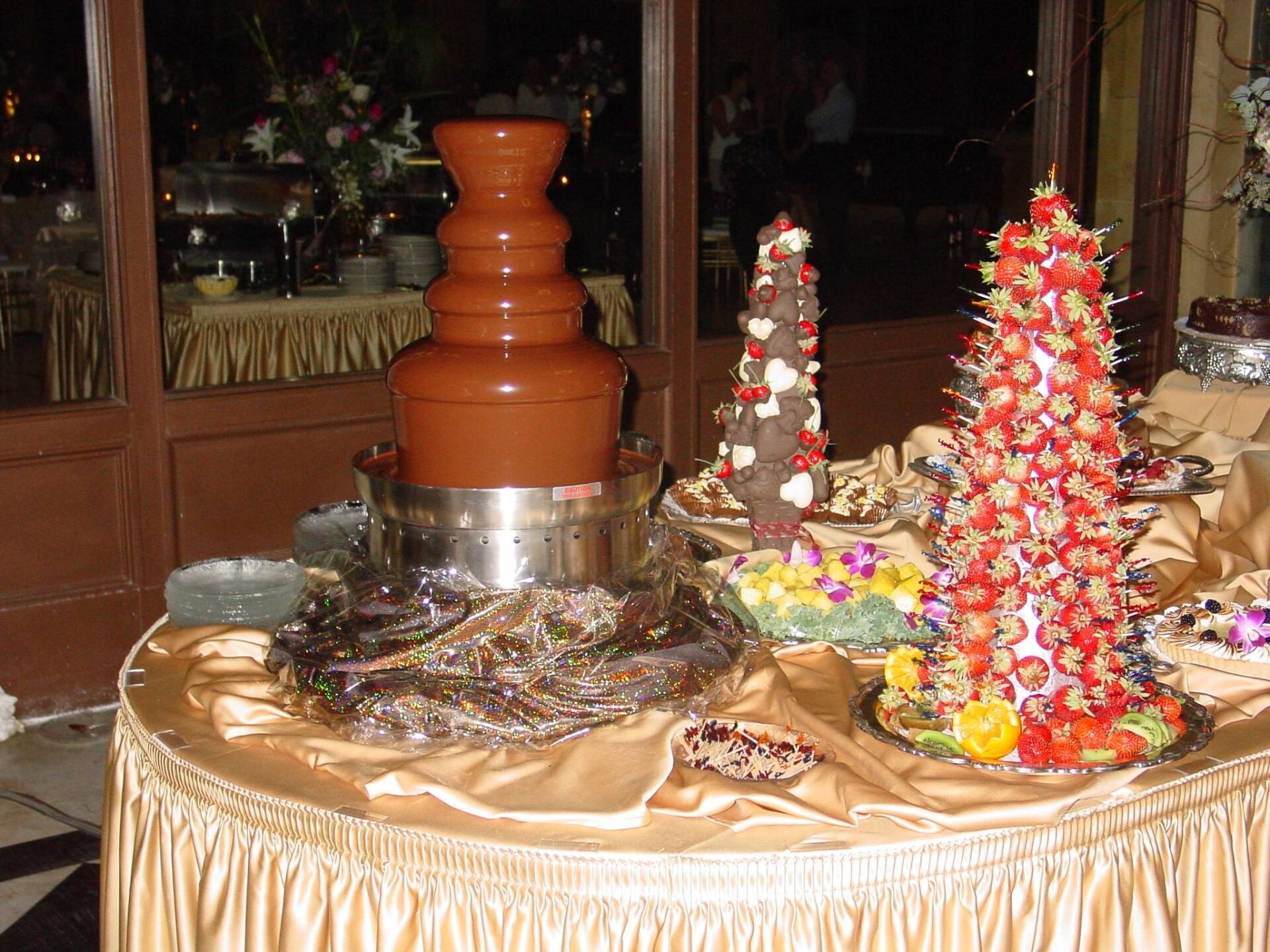 A table with a chocolate fountain and strawberries on it