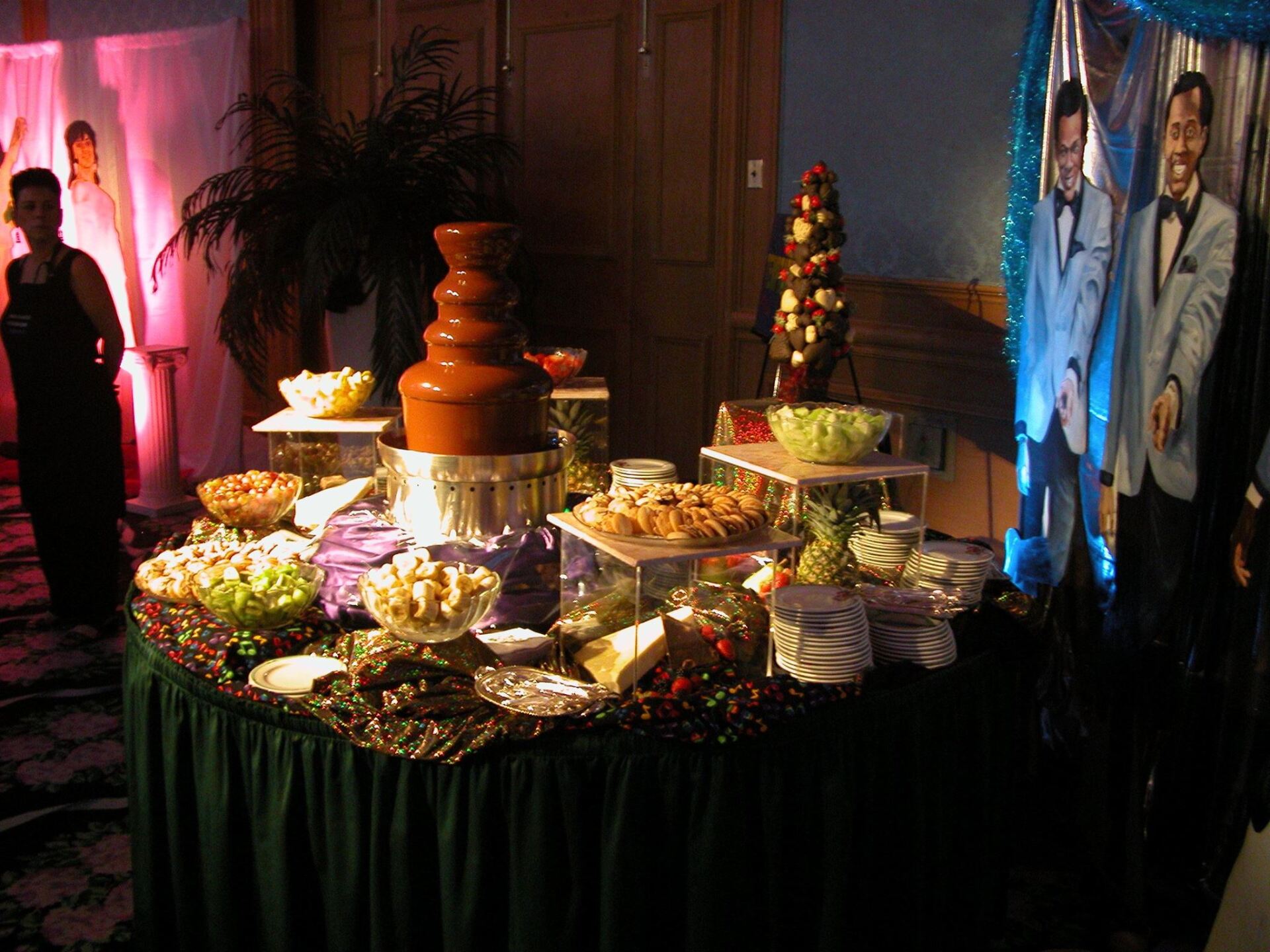 A buffet table with a chocolate fountain on top of it