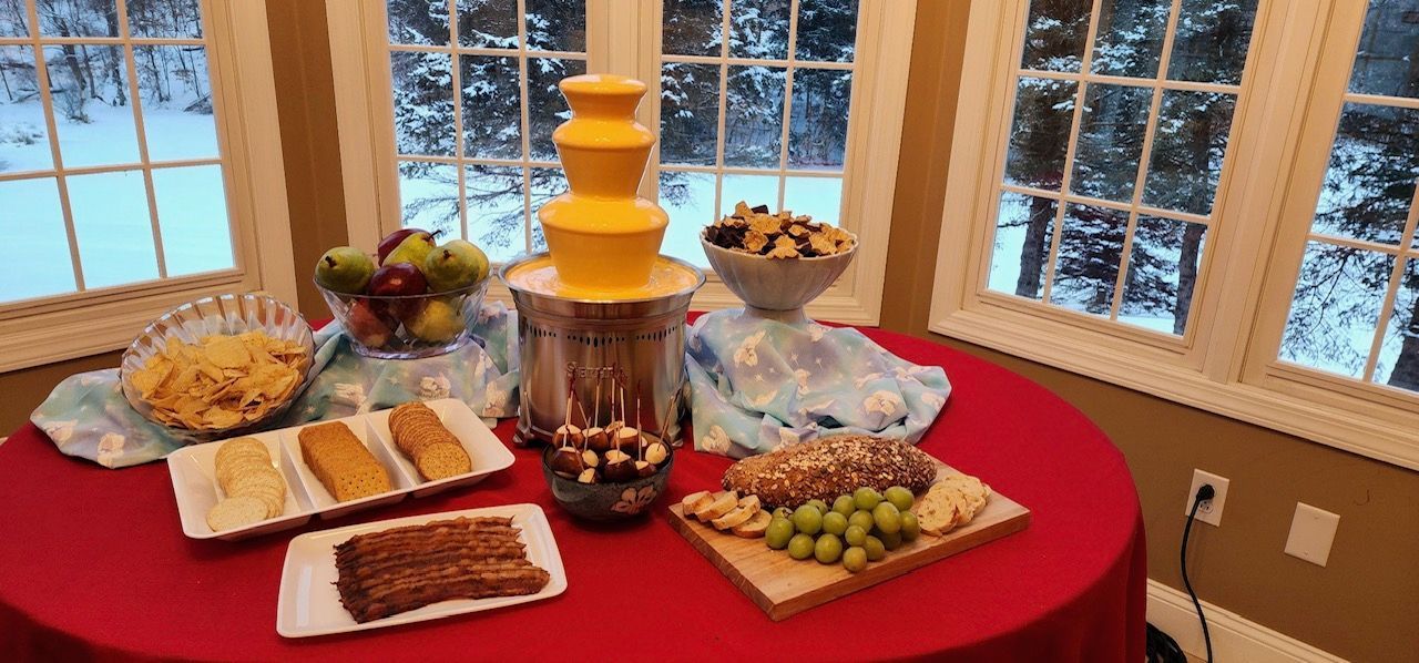 A table topped with plates of food and a chocolate fountain.