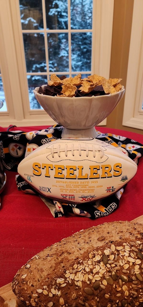 A bowl of food is sitting on top of a football on a table.