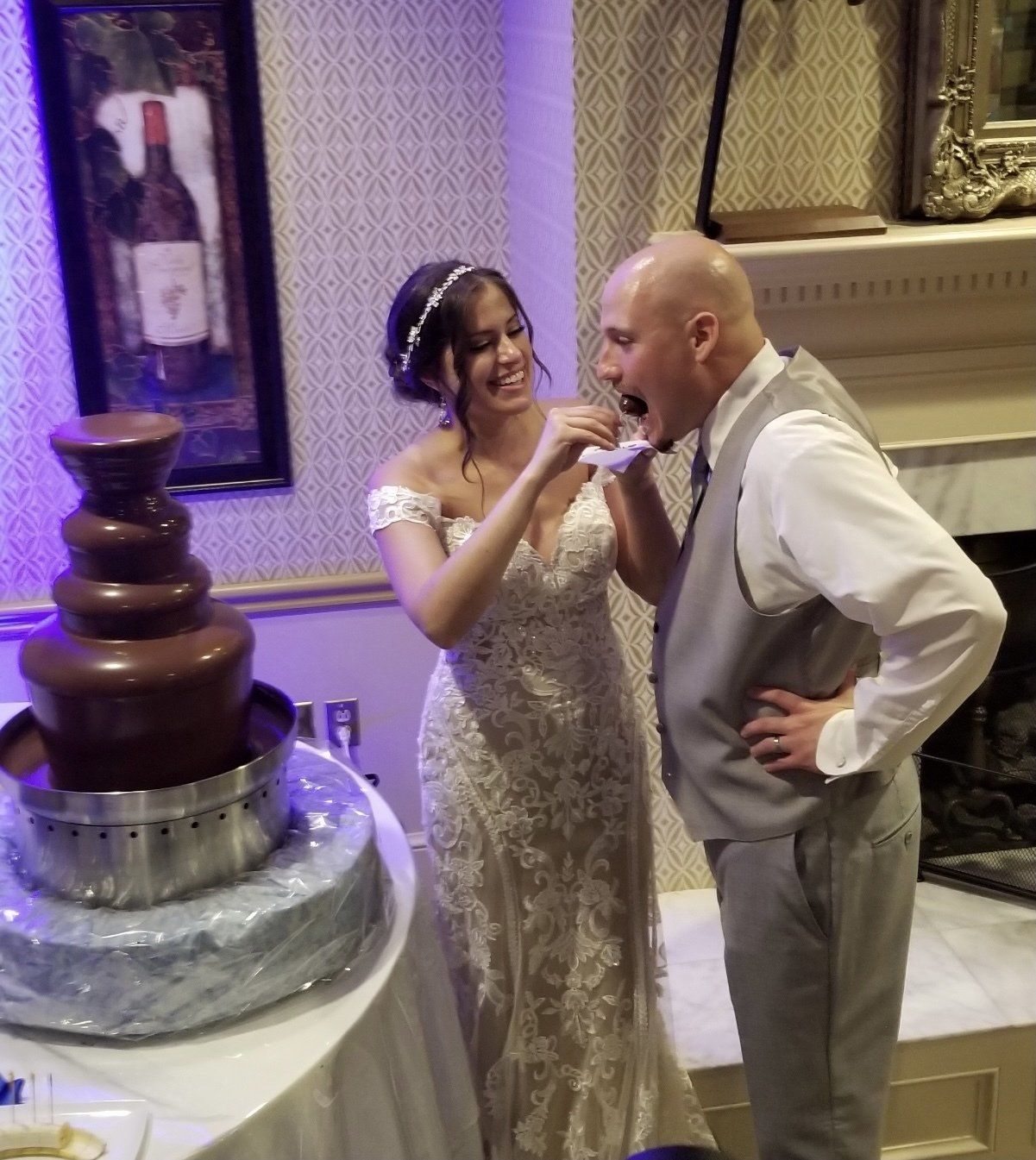 A bride and groom standing in front of a chocolate fountain
