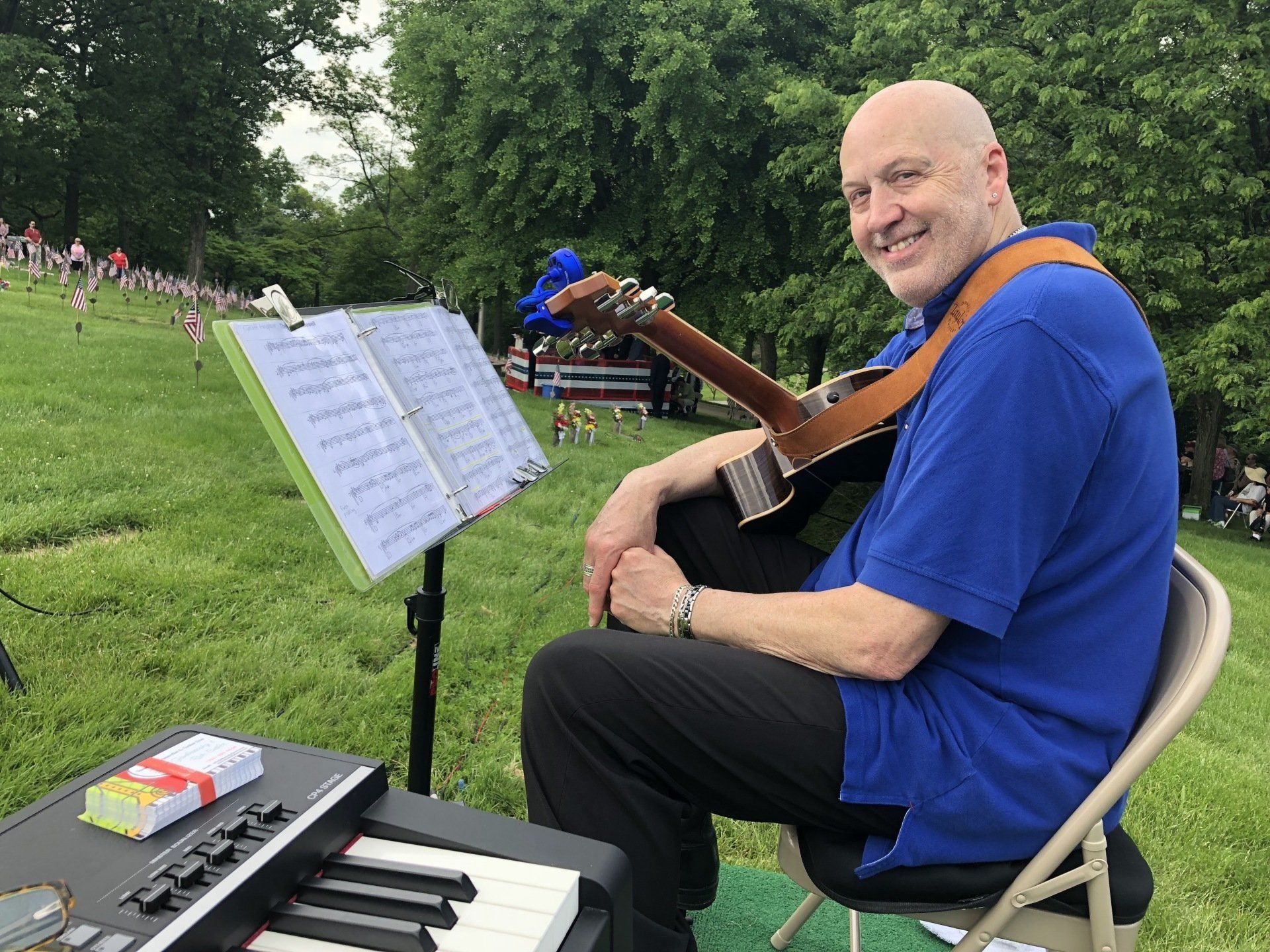 A man is sitting in a chair with a guitar and a piano.