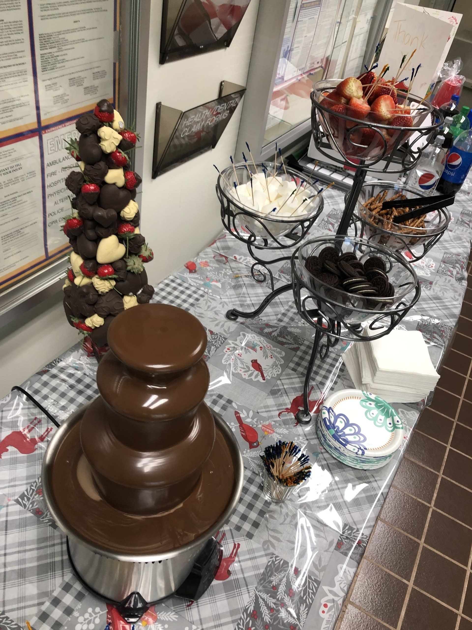 A table with a chocolate fountain and a strawberry tower on it