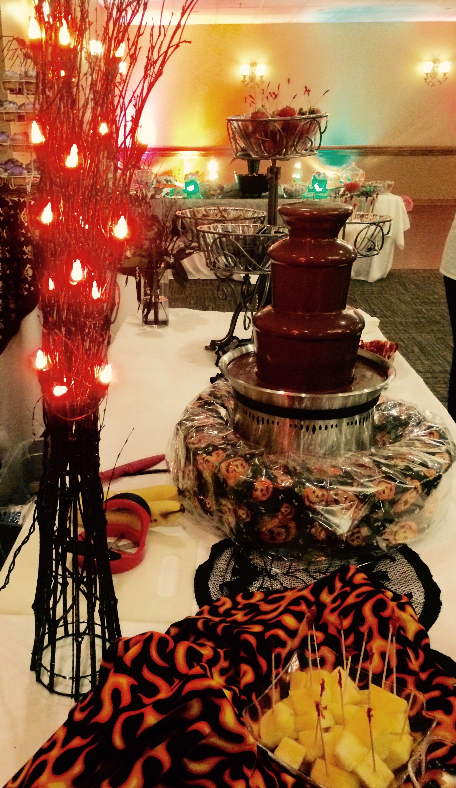 A table with a chocolate fountain and a bunch of food on it