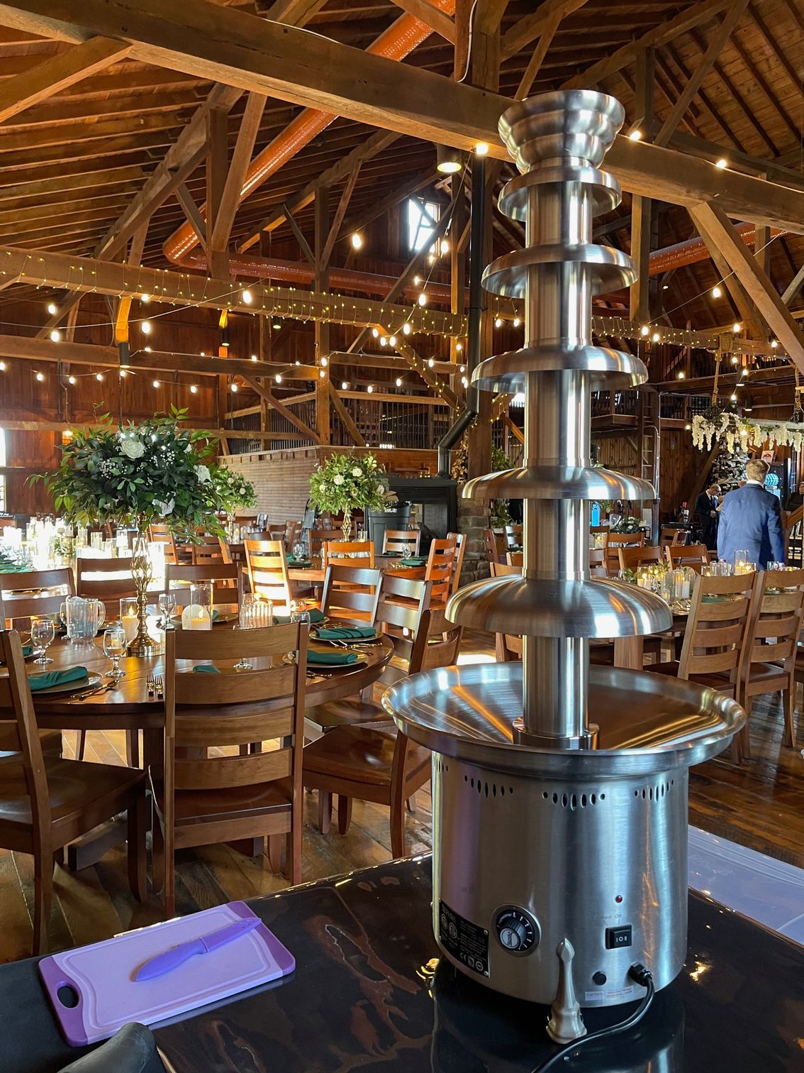 A chocolate fountain is sitting on a table in a restaurant.