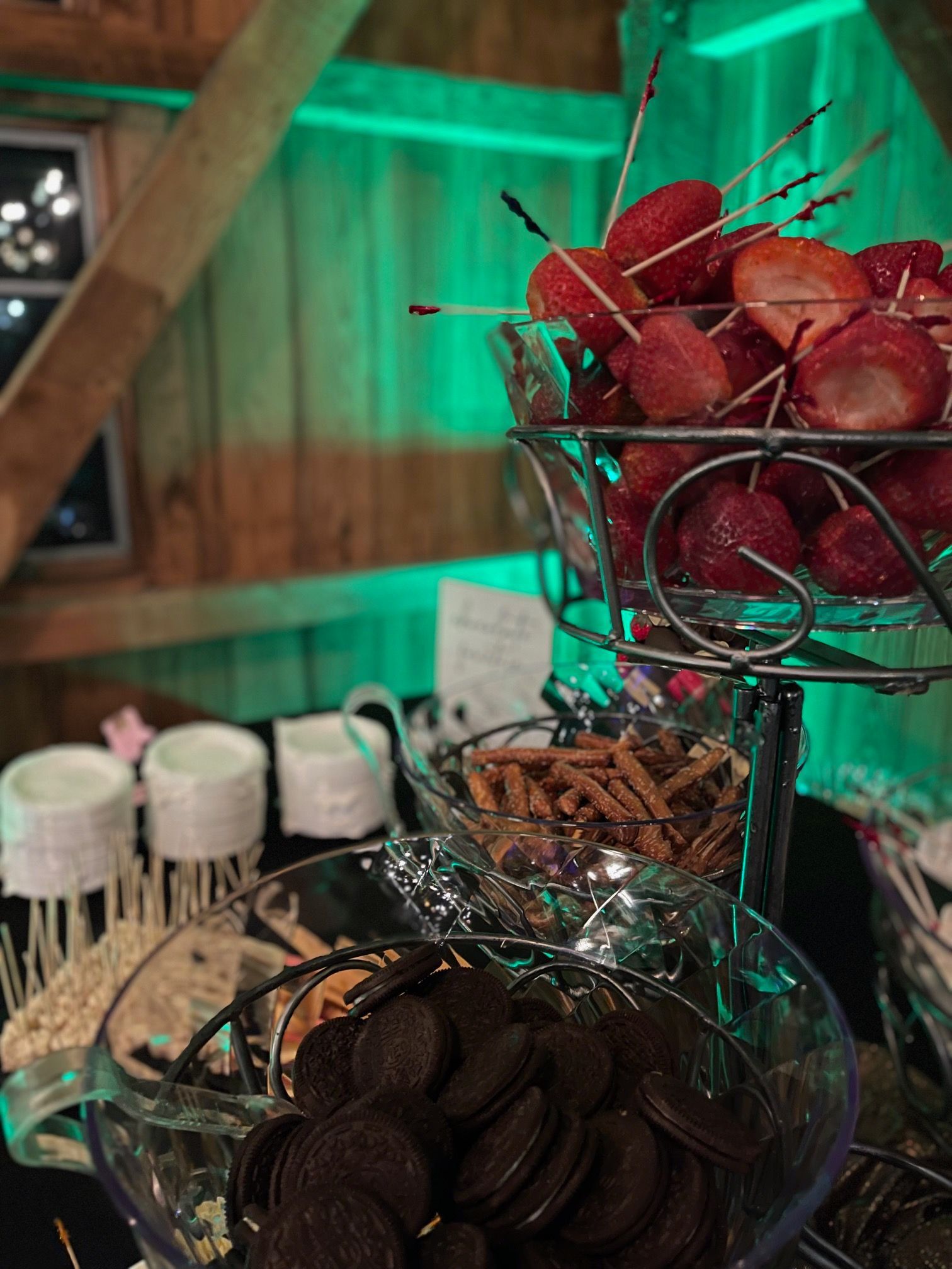 A table topped with bowls of food including strawberries and oreos.