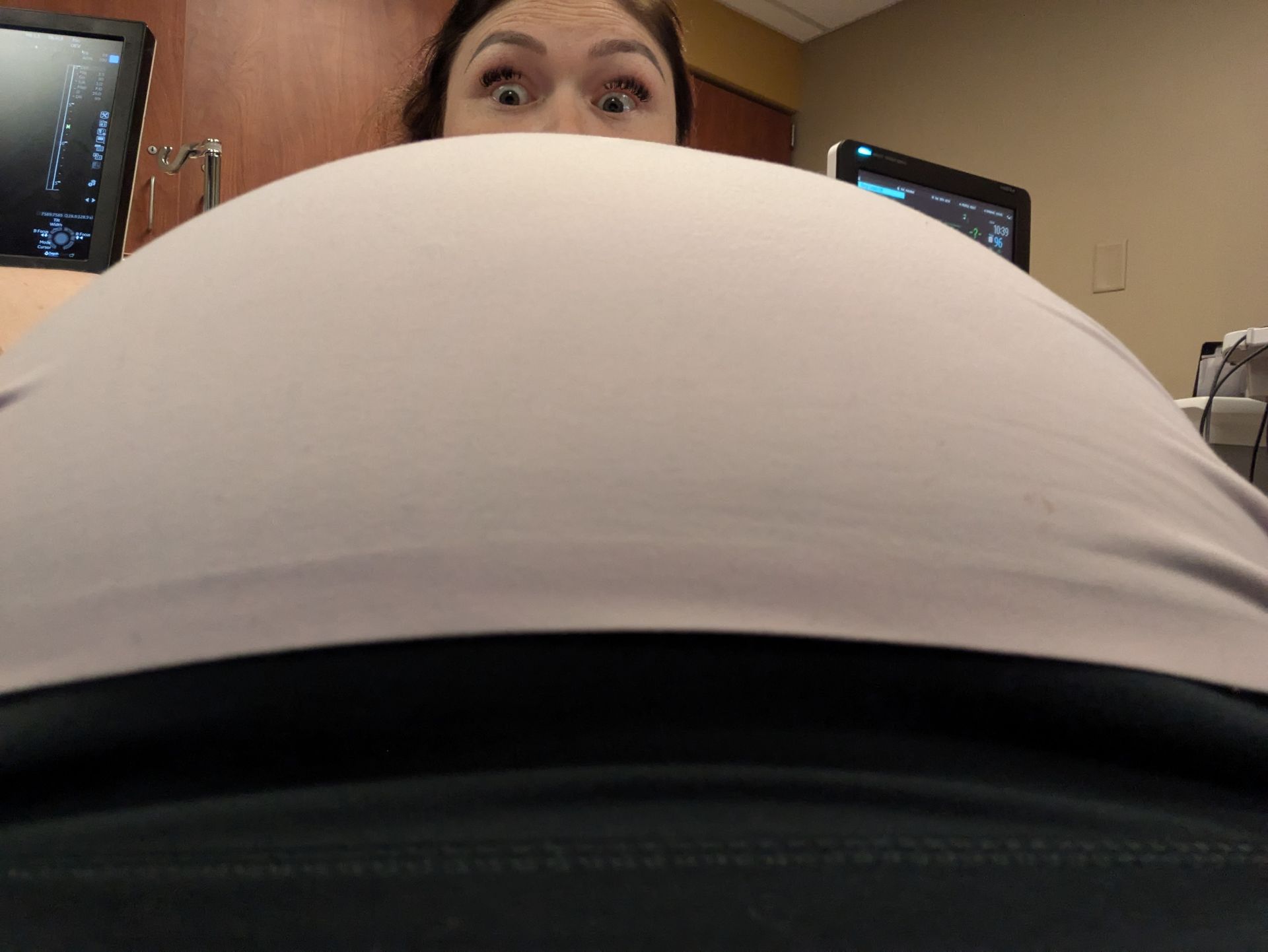 image of therapist laura ott peering over her pregnant belly