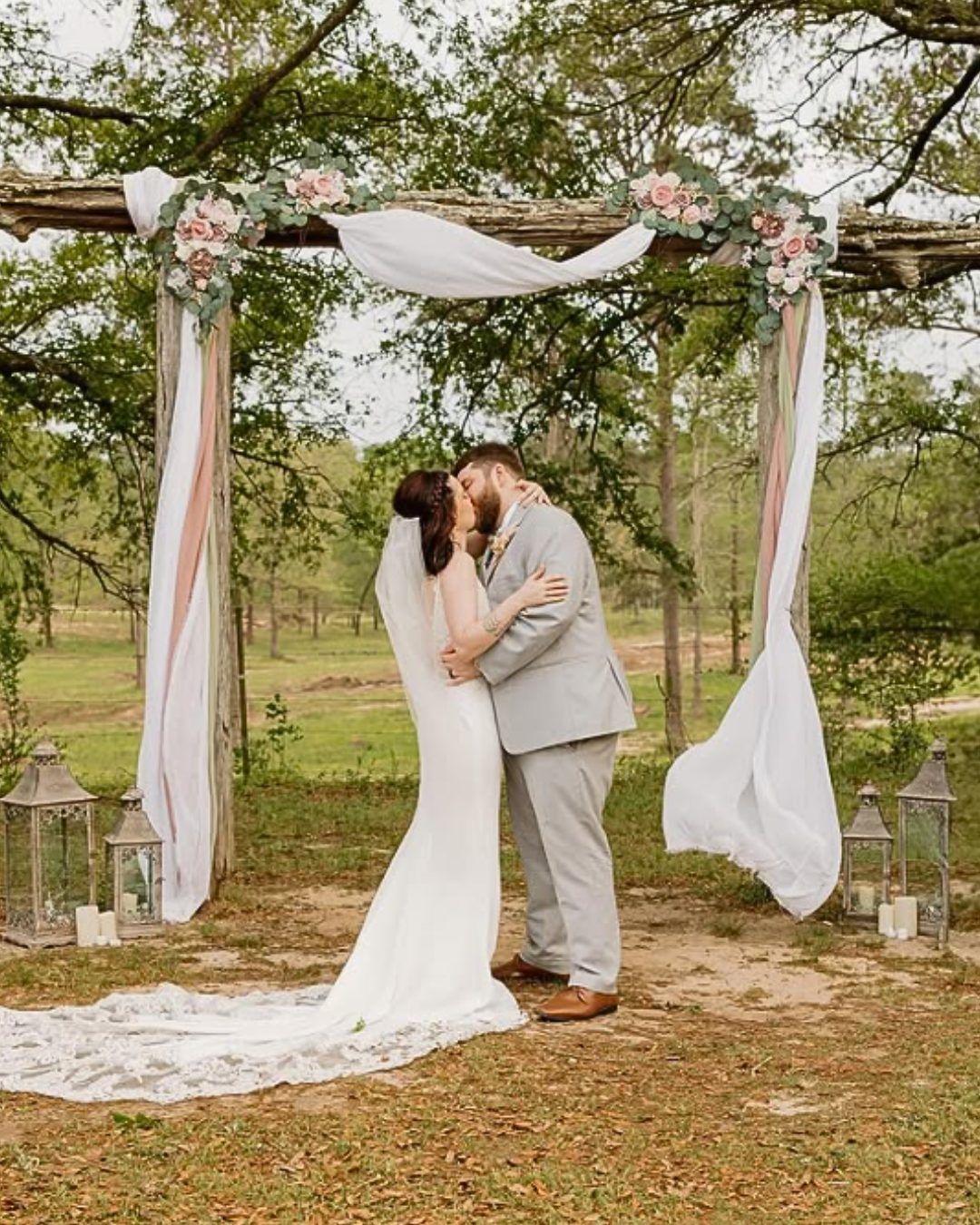 bride and groom kissing at altar at outdoor wedding ceremony