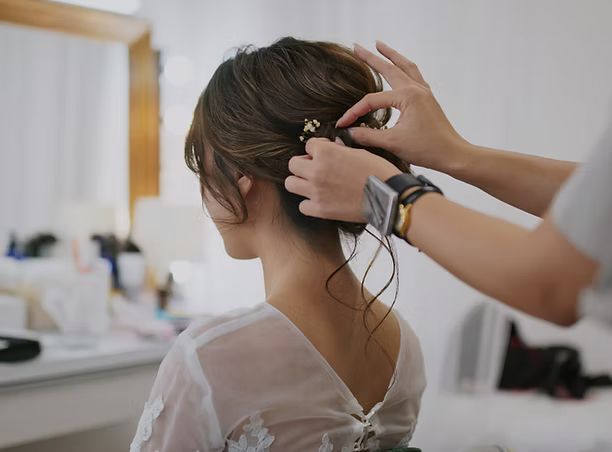A woman is getting her hair done by a hairdresser.
